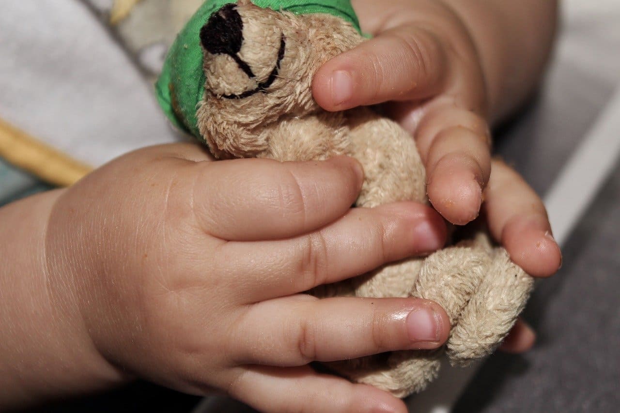 Baby-Teddy-festhalten-Greifen-Erspueren-Ertasten-Fingerspitzen-Kinderhaende-Tastempfinden-Tastrezeptoren-Tastsinn-Kritisches-Netzwerk-Beruehrungsreiz-Beruehrung